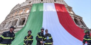 Italian firemen, the three-coloured flag covering the facade of the Colosseum